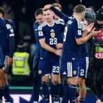 John McGinn celebrates Scotland's World Cup qualification from the corridor after drug test delay