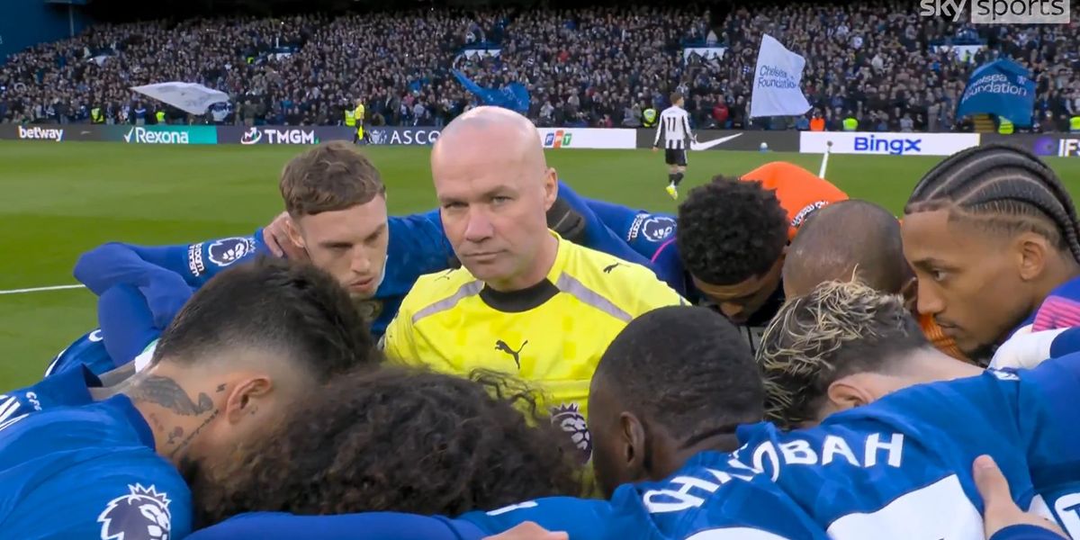 Chelsea team huddles around referee Paul Tierney ahead of Newcastle clash