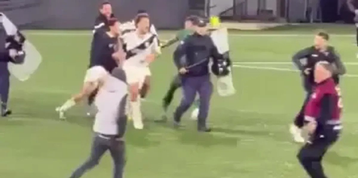 Goalkeeper confronts pitch invader attacking his own team during Uruguayan football match